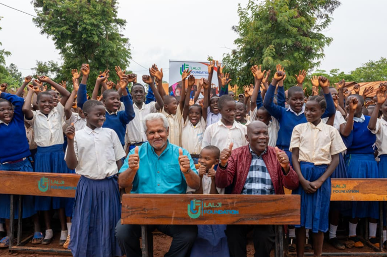 Lalji foundation leader and Kasulu students with new wooden school desks
