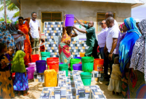 A woman carrying a bucket of clean water from mateteni shallow well.