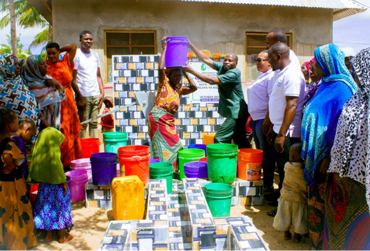 A woman carrying a bucket of clean water from mateteni shallow well.
